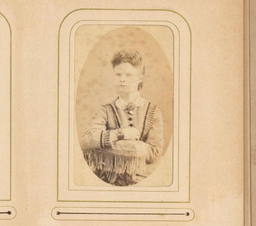 Portrait of a seated woman, leaning on the back of a chair