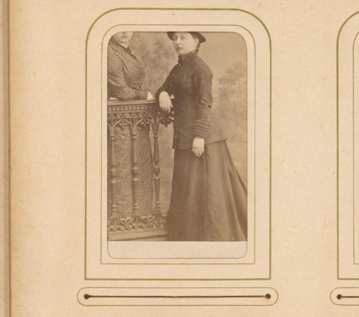 Portrait of two young women, standing by a fence