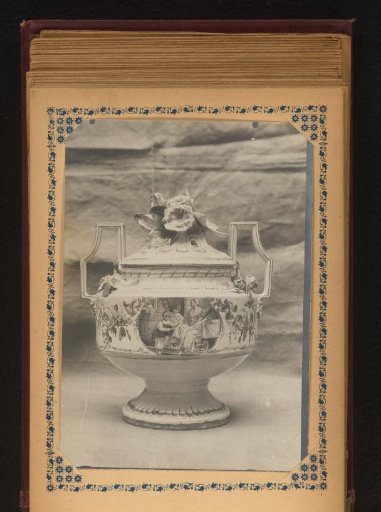Pot with lid, decorated with flowers and painted with a mother and two children in an interior
