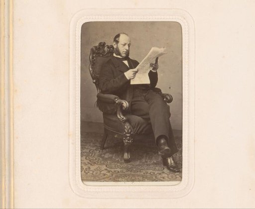 Portrait of a seated man, reading the newspaper