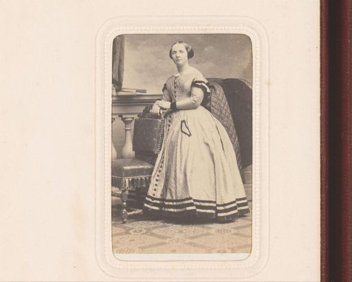 Portrait of a young woman, standing by a chair