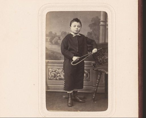 Portrait of a standing boy with riding whip in hand