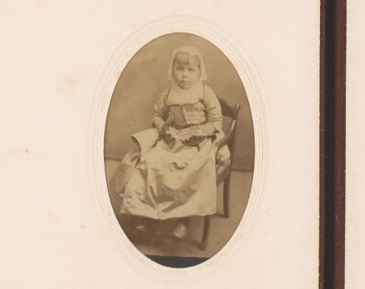 Portrait of a girl with a white traditional cap and a fan in her hand