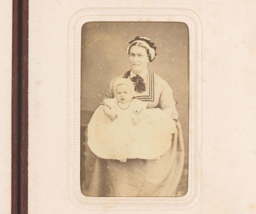 Portrait of a seated woman with a baby in a white dress on her lap