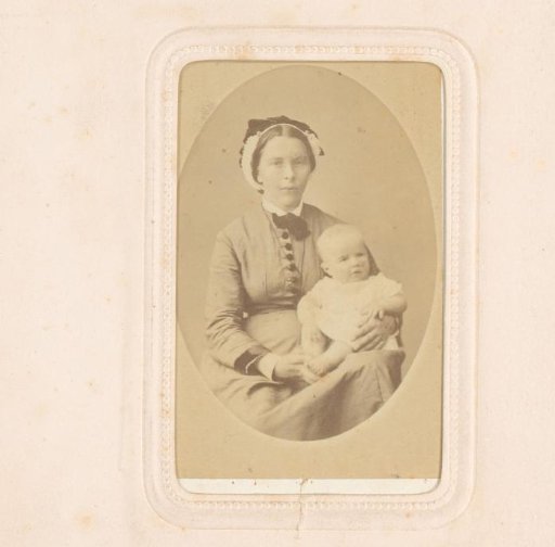 Portrait of a seated woman with a baby in a white dress on her lap