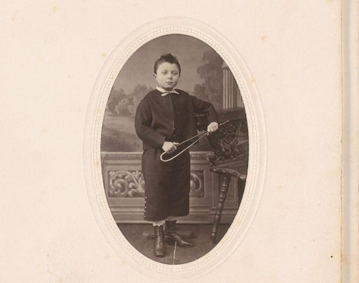 Portrait of a standing boy with a riding whip in his hand