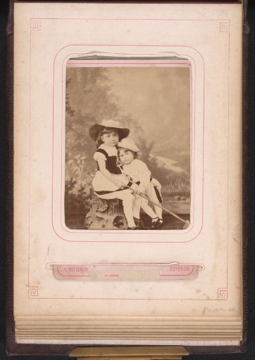 Two girls with hats before a landscape setting