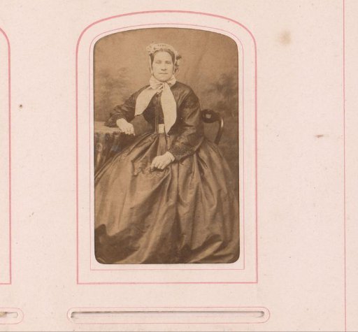 Portrait of a seated woman with cap and bow