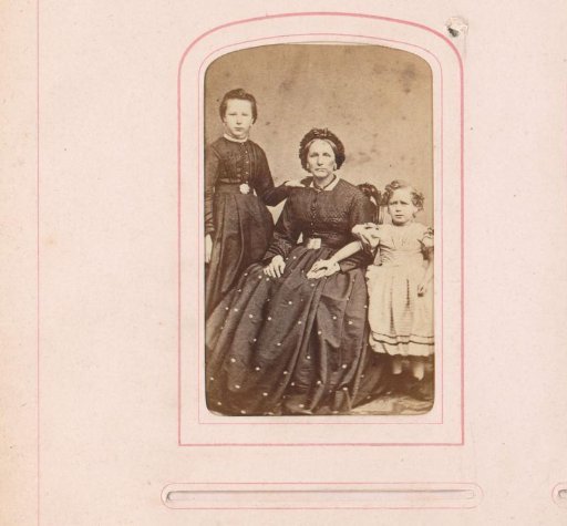 Group portrait of a seated woman with two standing girls