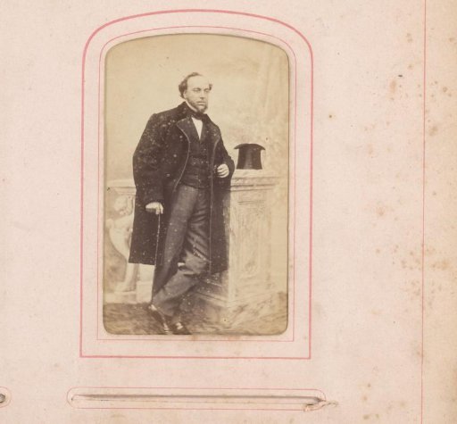 Portrait of Bastiaan de Greef standing by a pedestal with hat and cane