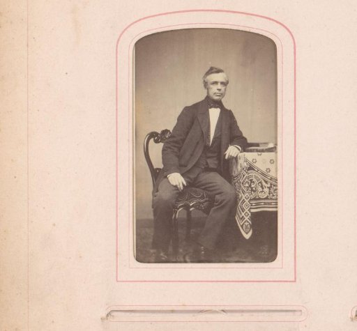 Self-portrait seated at a table