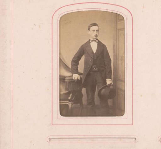 Portrait of a standing boy with hat in hand