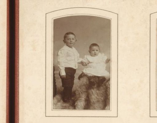 Portrait of a standing boy and a sitting baby