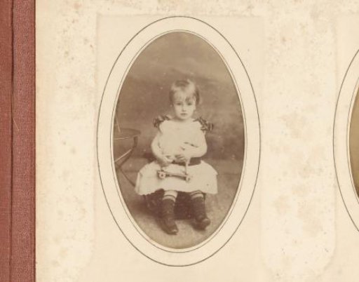 Portrait of a seated girl with toys in her hand