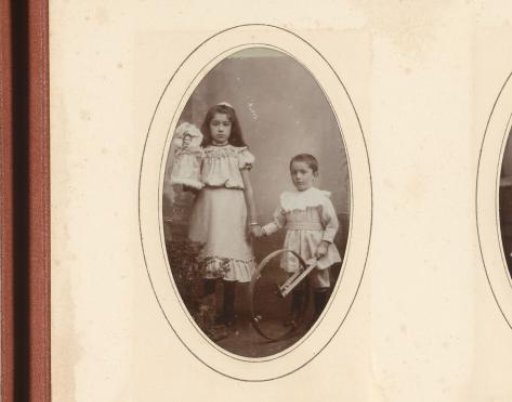 Portrait of a girl with a doll and a boy with a hoop