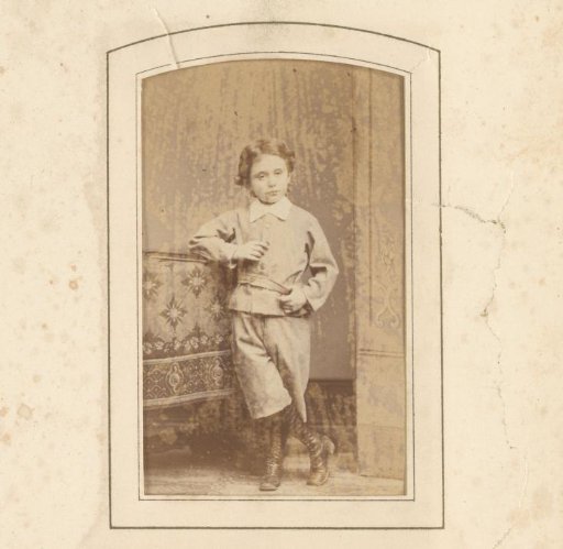 Portrait of a boy, standing by a table with a book