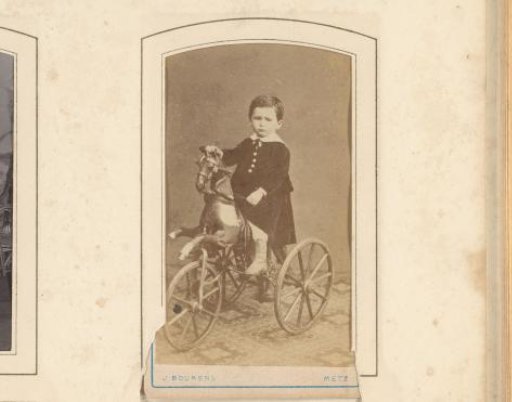 Portrait of a boy on a toy horse with wheels