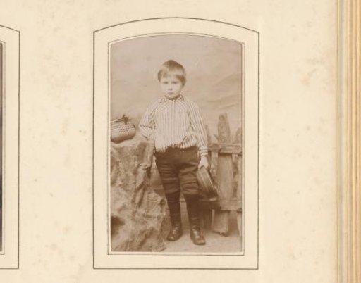 Portrait of a Young Boy with a Cap in His Hand, Standing in a Setting