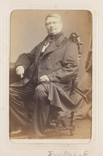 Portrait of a seated man with spectacles