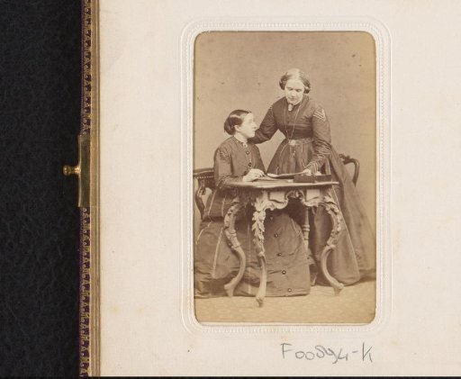 Portrait of two women at a table with writing materials