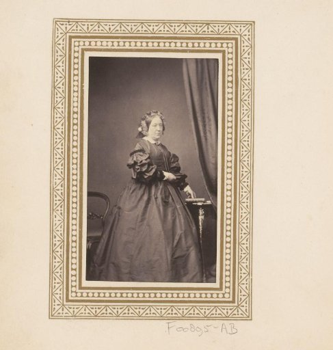 Portrait of a standing woman by a table