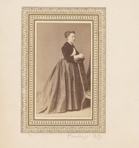 Portrait of a standing woman by a chair