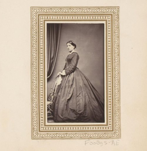 Portrait of a standing woman by a chair