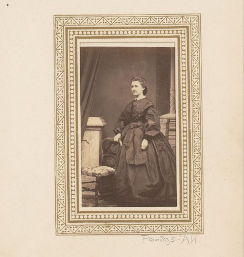 Portrait of a woman, standing by a chair