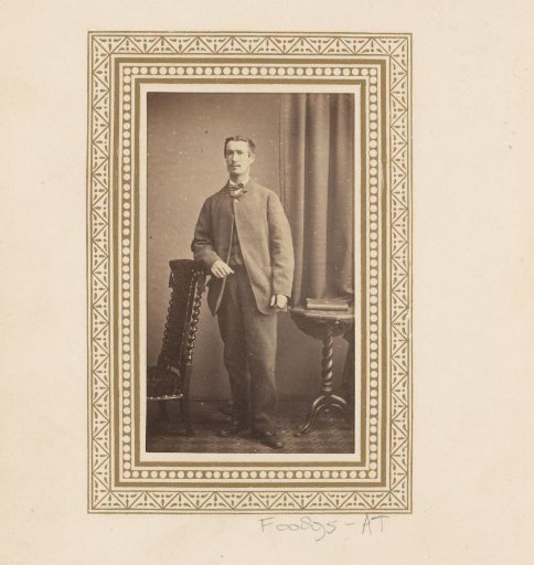 Portrait of a standing man by a chair