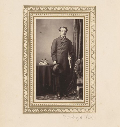 Portrait of a standing man, with umbrella and hat in hand