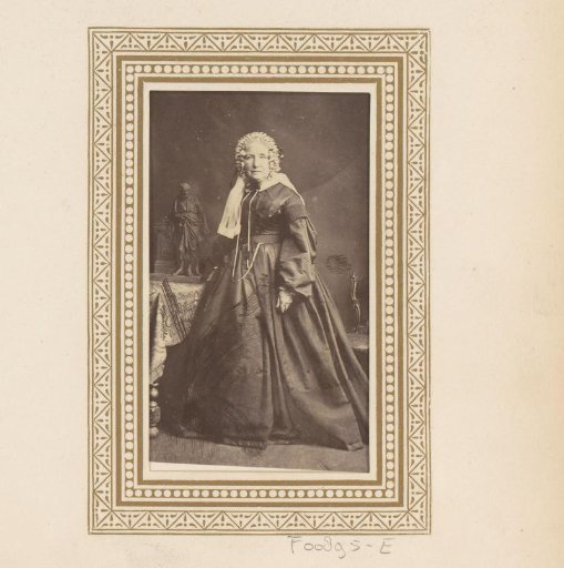 Portrait of a woman, standing by a table with a sculpture
