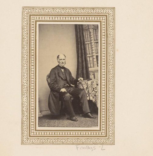 Portrait of a seated man at a table with books
