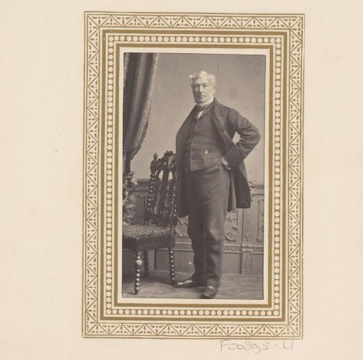 Portrait of a man, standing by a table