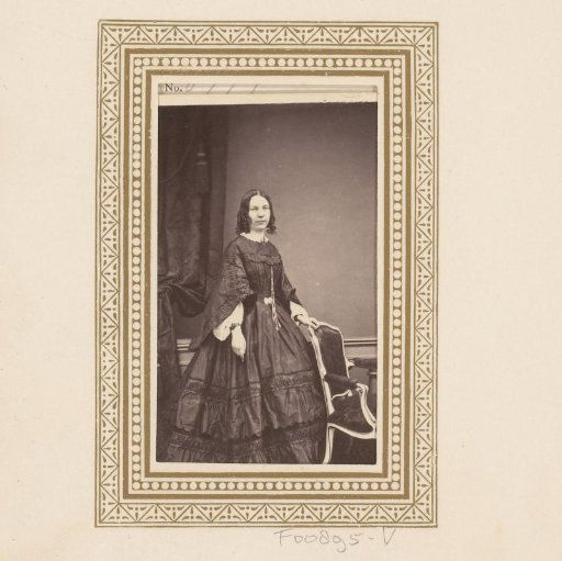 Portrait of a woman, standing by a chair