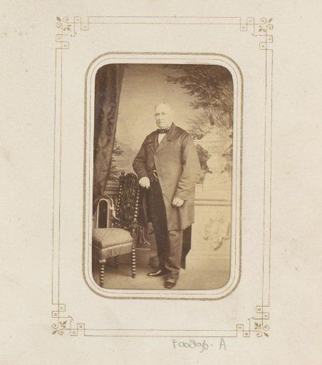 Portrait of a standing man by a chair