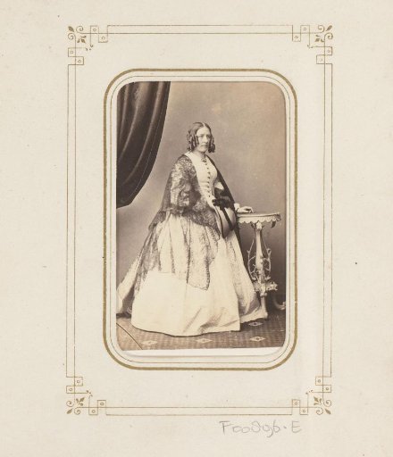 Portrait of a woman, standing by a table