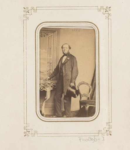 Portrait of a standing man with a top hat in his hand