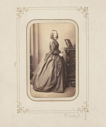 Portrait of a standing woman by a cabinet