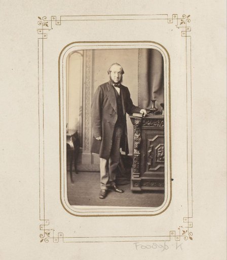 Portrait of a standing man by a cabinet