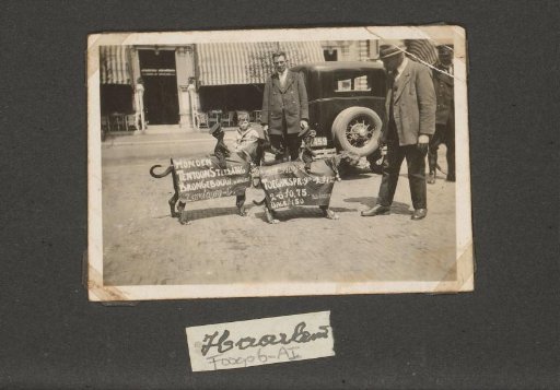 Dogs with advertising signs for the dog exhibition with handlers on the street in Haarlem