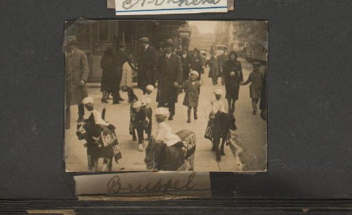 The Puppet Doctor with a child by the hand and dogs with advertising signs and confectioner puppets on their backs