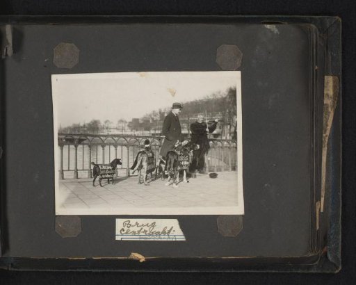 The Puppet Doctor with dogs with advertising signs for the Sinterklaas celebration on their backs on a bridge with violin player