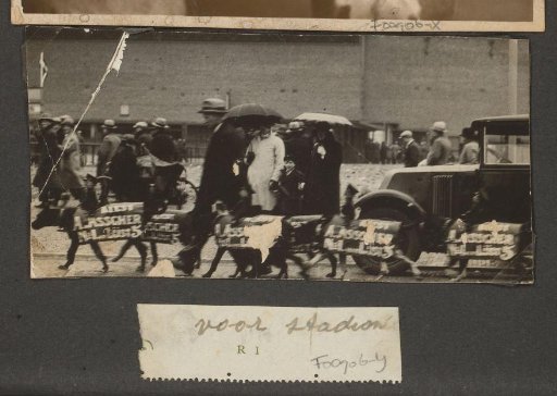 Procession with dogs carrying advertising signs for Asscher of list 5 and public in the rain
