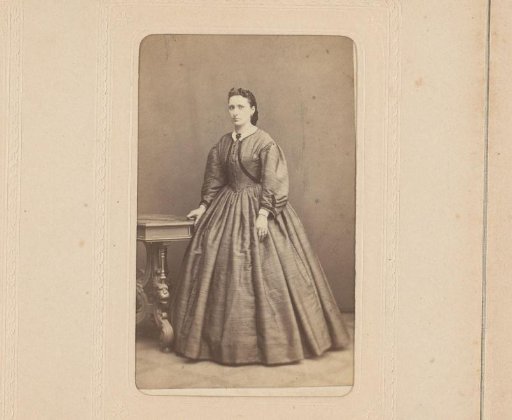 Portrait of a woman, standing by a table