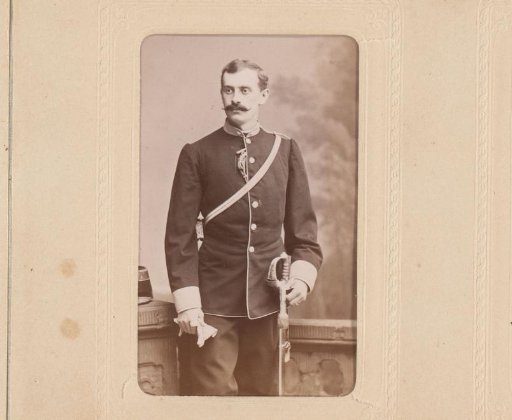 Portrait of a standing man in military uniform with a sword