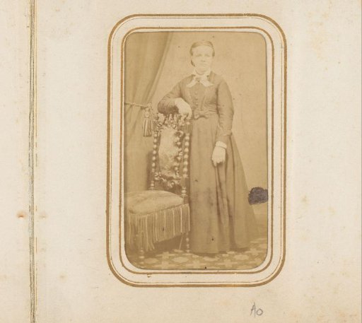 Portrait of a woman standing by a chair
