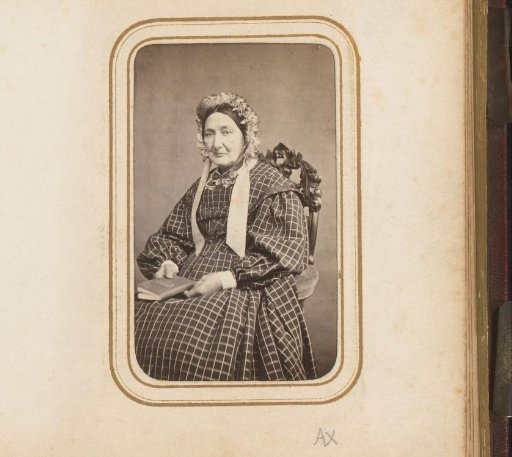 Portrait of a seated woman with a cap and book