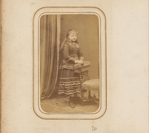 Portrait of a girl standing by a chair