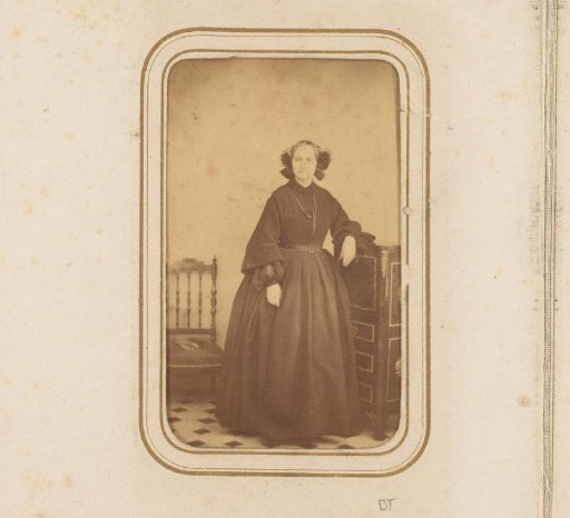 Portrait of a woman standing by a cabinet