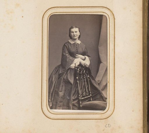 Portrait of a woman, standing by a chair